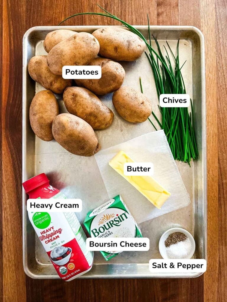 An overhead view of a sheet pan with all of the ingredients required to make Boursin mashed potatoes.