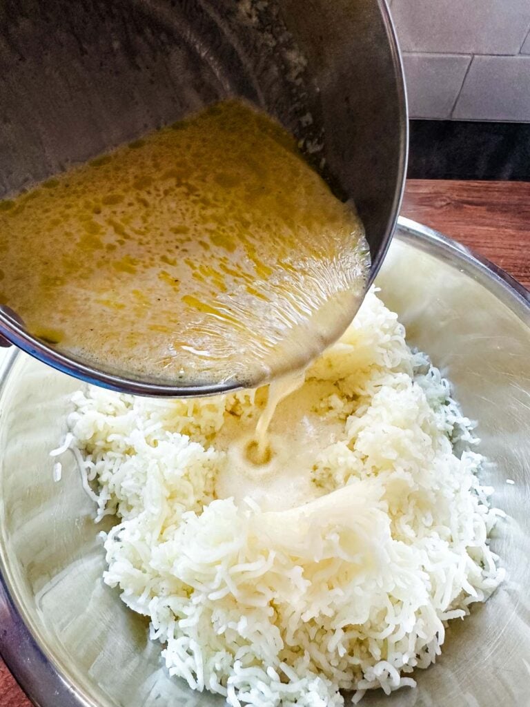 Boursin cheese and cream mixture being poured into the riced potatoes.
