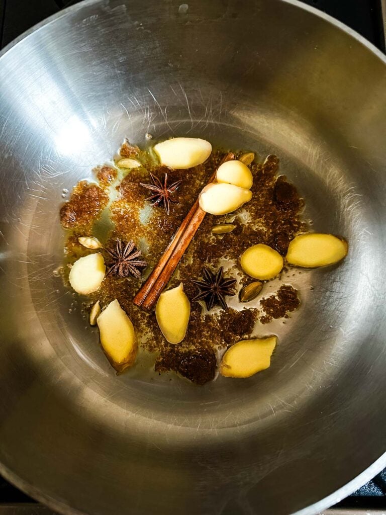 Whole spices blooming in sugar and olive oil in a saucepan over low heat.